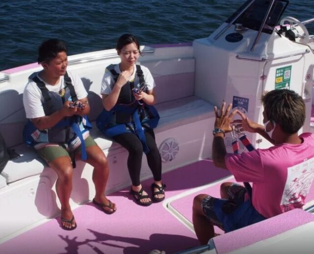 パラセーリング前にインストラクターから説明を受ける観光客