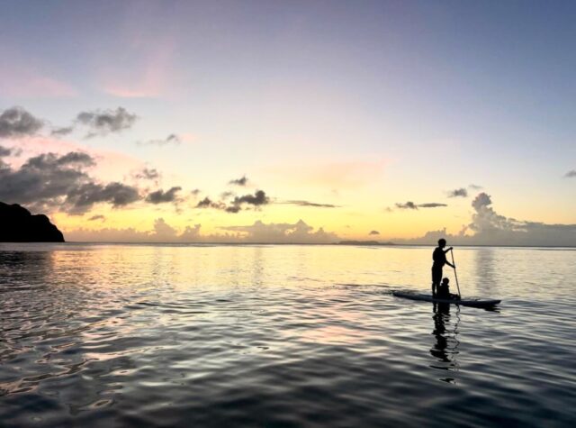 背景の夕暮れが美しい慶良間の海でのSUP体験
