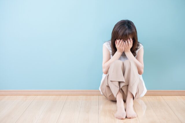 ショック　苦手　頭を抱える女性